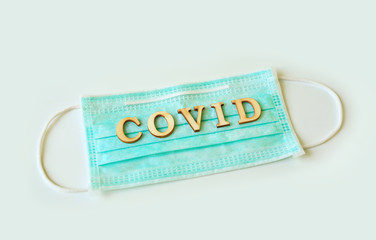 Medical shielding mask with word COVID isolated over white background.