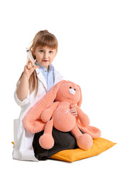 Poster - Cute little doctor with toy on white background