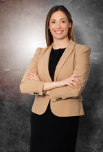 Beautiful Businesswoman Arms Folded Standing, Smiling With Black Suit And Brown Jacket. On Grunge Faded Background.