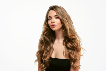  Portrait of young beautiful woman isolated at white background. Blonde girl with long and shiny wavy hair . Smiling friendly girl with curly hairstyle