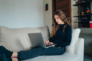 Wall Mural - Giovane bella ragazza studente/ lavoratrice studia/ lavora da casa con il computer. Smart working e distanza sociale. Lavorare con la tecnologia 