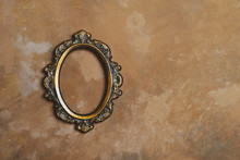 Empty Oval Bronze Picture Frame On Vintage Brown Wall. Photo Frame Mockup.