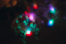 Defocused Image Of Illuminated Christmas Lights At Night