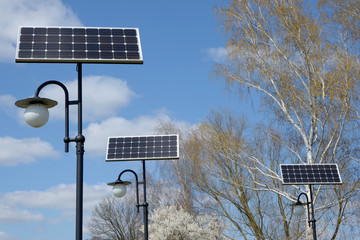 solar panels at the lanterns in the park against the blue sky
