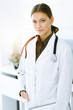 © Iryna - Woman-doctor standing and looking at camera in sunny clinic. Perfect medical service. Medicine and healthcare