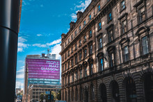 A View Of A Glasgow Street In Front Of A Tall Building