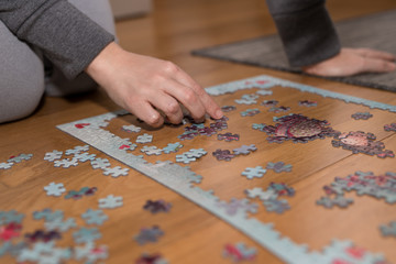 Mother and daughter with a jigsaw confined at home by coronavirus