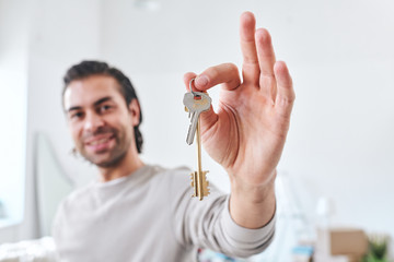 Wall Mural - Hand of happy young male settler or buyer of new house showing you the key