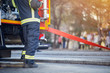 © luckybusiness - Firefighter in protective uniform. Fireman standing near a fire truck. Fire truck with equipment.