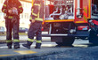 Profesional Fire truck with fire fighting equipment and firemen in protective clothing, helmets.