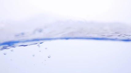 Wall Mural - Water splash surface filling the frame with the water drop and waving liquid with an air bubble on a white background. Slow motion 1080p 23.98fps