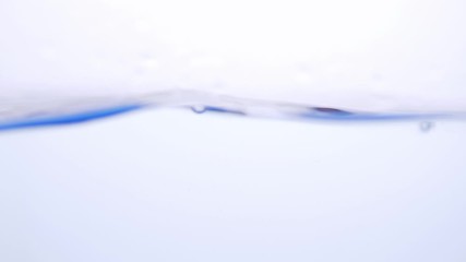 Wall Mural - Water splash surface filling the frame with the water drop and waving liquid with an air bubble on a white background. Slow motion 1080p 23.98fps