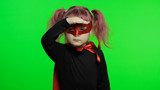 Fototapeta  - Funny child girl in costume and mask plays super hero. National superhero day