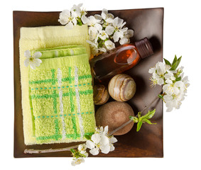 SPA body care concept. Towel, bath salt and essential oil with spring flowers in wooden bowl isolated on white background