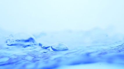 Soft blur focus of Abstract water splash surface filling the frame with the water drop and waving liquid with an air bubble on a white background and copy space.