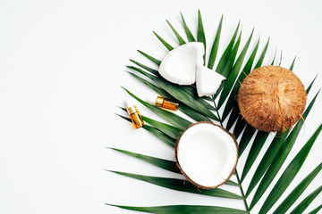 Wall Mural - natural coconut oil for hair, spa organic cosmetic concept. flat lay, top view tropical palm leaf, c