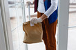 © Angelov - Grocery delivery man wearing medical gloves and face mask. Online shopping and delivery for grocerys, wine and food. Self Quarantine during coronavirus pandemic. Food delivery service courier