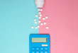© splitov27 - Calculation of the cost of medical expenses. Calculator and pills bottle on blue-pink pastel background. Top view. Minimalism