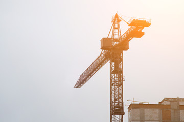 Extensive scaffolding providing platforms for work in progress on a new apartment block,Tall building under construction with scaffolds,Freestanding tower crane on a building site