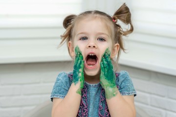 Little girl paints with fingers