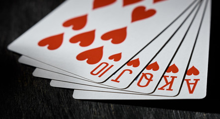 Royal flush on a black background. Playing card in soft focus. The concept of victory.