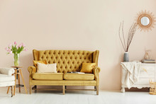 Cozy Living Room Interior Of Retro Armchair, Vintage Wooden Chest Dwarf And Vintage Couch On The Background Of The Beige Wall And Painted Wooden Floor