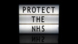 Protect the NHS letters on a light box on reflective surface