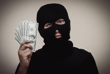 Portrait Of Thief Holding Paper Currency Against Gray Background