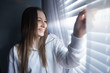 © Haydiddle - Teenage girl looking out the window during a period of isolation