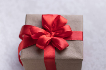 White gift box with red ribbon, black background flat lay for stock image