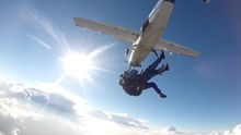 Low Angle View Of Skydiver Jumping From Airplane Against Sky On Sunny Day