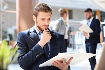 Wall Mural - Portrait of young man sitting at his desk in the office.