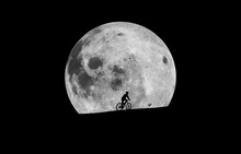 Silhouette Man Riding Bicycle Against Moon At Night