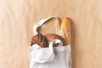 Zero waste concept with fresh bread in cloth bag eco friendly on brown, beige background