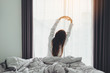 © joyfotoliakid - Asian woman wake up on bed stretching feeling happy and fresh enjoying in the morning