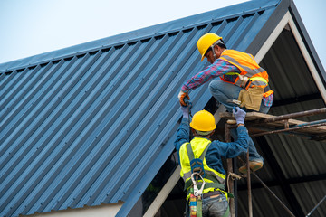 Aufkleber - Roofer using air or pneumatic nail gun and installing metal roof tile on top roof,Builder Working On Roof Of new building.