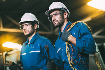 Professional team engineering Man Worker at industrial factory wearing uniform and hardhats at Metal lathe industrial manufacturing factory. Engineer Operating  lathe Machinery