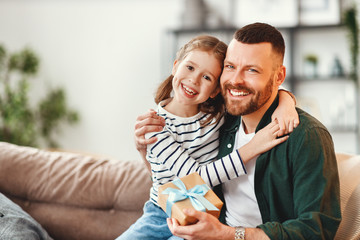 Wall Mural - cute girl hugging happy father with gift.