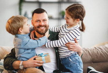 Wall Mural - little siblings congratulating happy father at home.