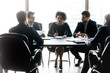 © fizkes - Diverse business partners discussing project, business strategy, contract terms sitting at table in modern boardroom, negotiations, employees listening to African American businesswoman mentor