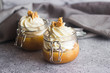 Delicious dessert in a jar. Banana dessert with caramel and whipped cream, garnished with cookies and nuts. 