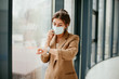 © Катя Іваськевич - young woman working in the office in mask. coronavirus. pandemic. covid - 19. young woman looking out window.