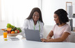 Black women nutritionist and patient looking at laptop screen