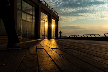 Man walking with a note in his hand during sunset