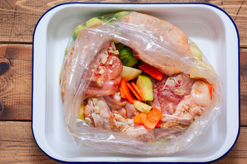 Step by step cooking of baked chicken with vegetables, step 5 - before baking in the culinary sleeve, selective focus