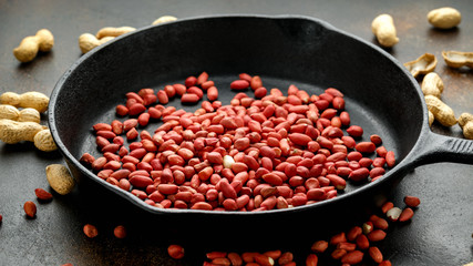 Wall Mural - Peanuts ready for roast in cast iron pan