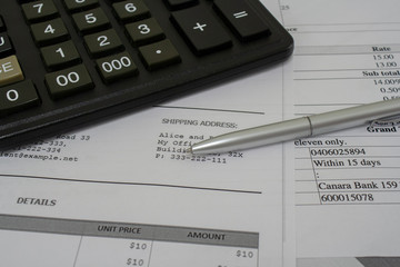 Macro shot of calculator , pen and documents with figures