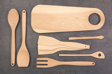 wooden spoon and wooden chopping board on dark table. top view.