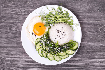 Wall Mural - Rice with cucumber, scrambled eggs, microgreen and Japanese wakame seaweed salad.