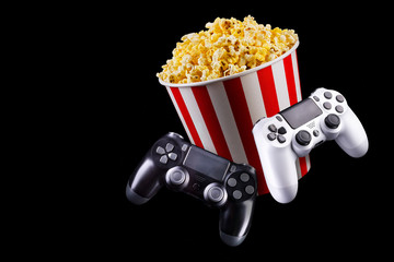 Canvas Print - Flying popcorn and video game joystick gamepad isolated on a black